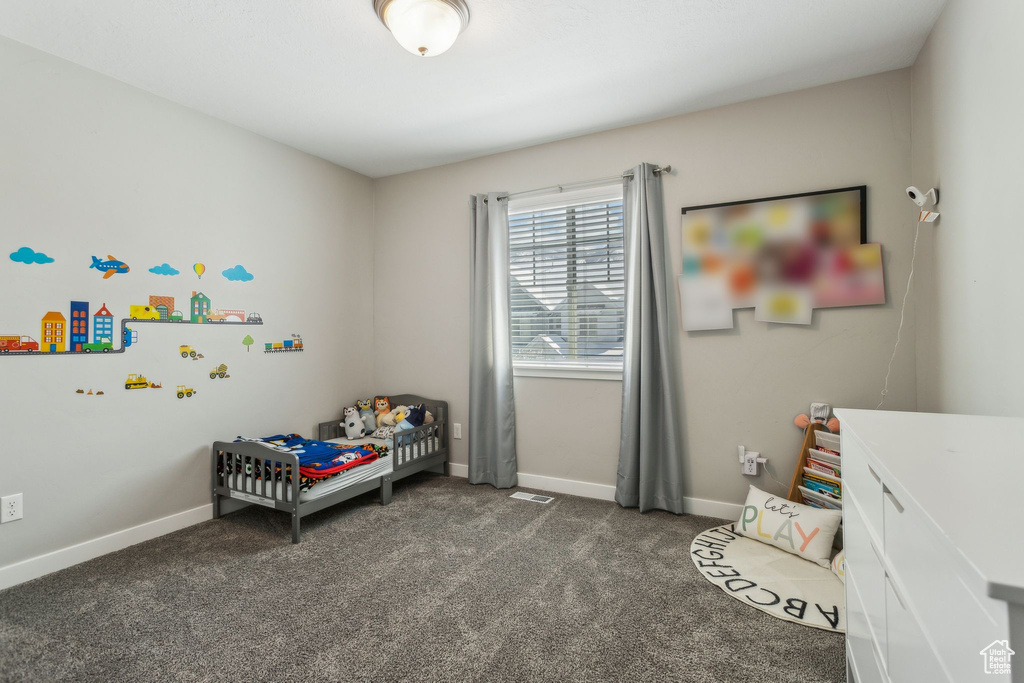 Bedroom with dark carpet, baseboards, and visible vents