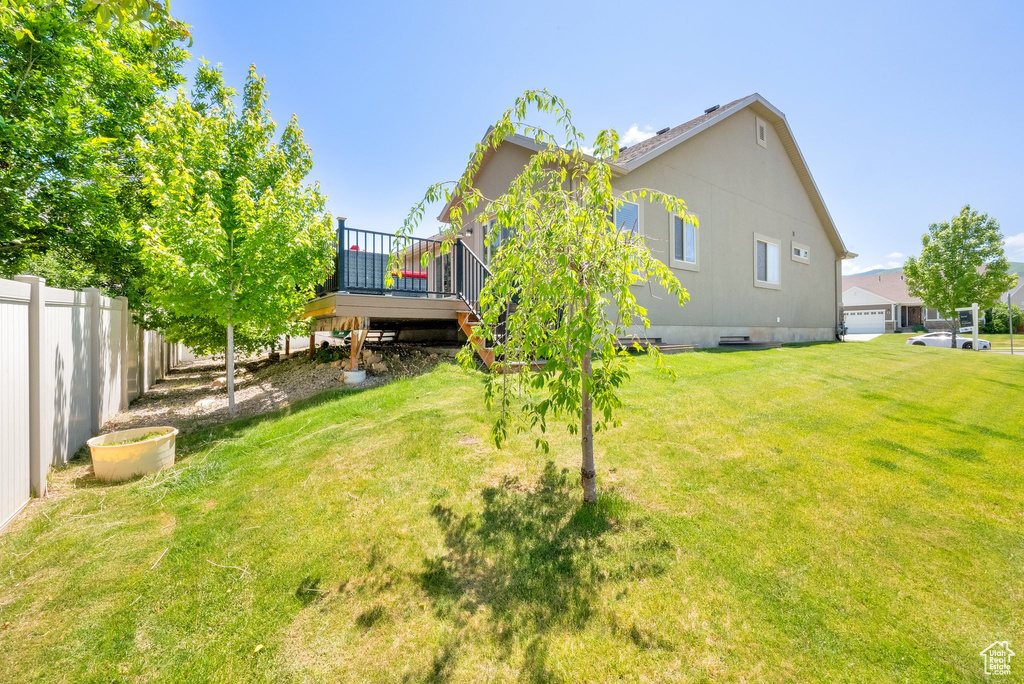 View of yard with a wooden deck and stairway