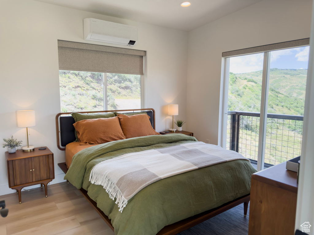 Bedroom featuring recessed lighting, a wall mounted AC, and light wood-style floors