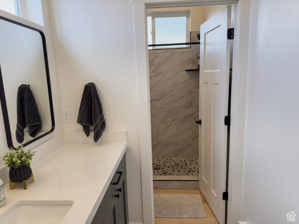 Bathroom with tiled shower and vanity
