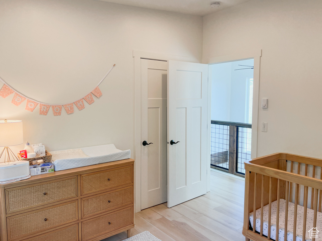 Bedroom featuring light wood-style floors and a nursery area
