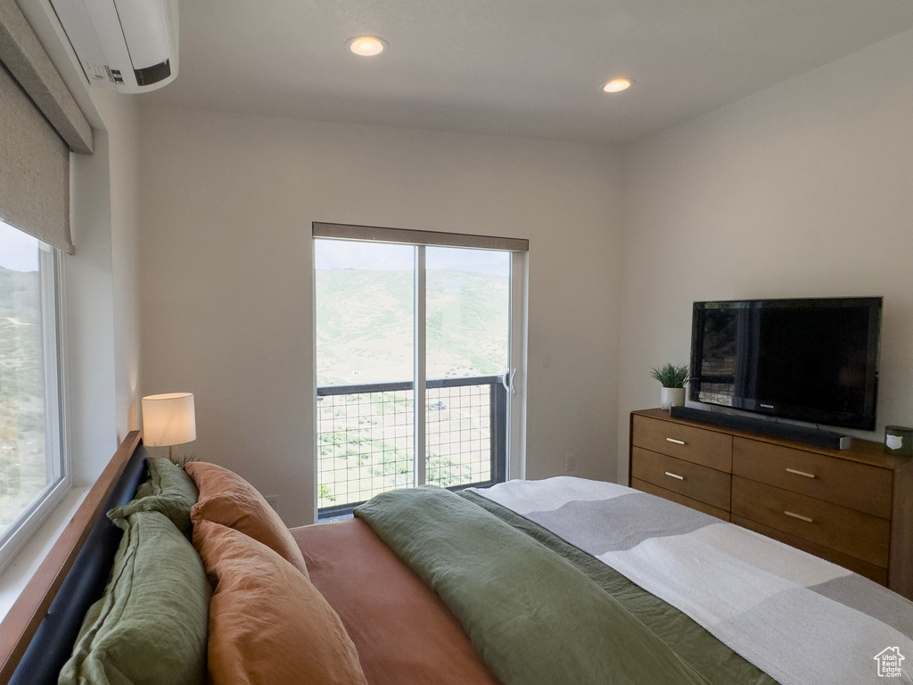 Bedroom with recessed lighting, a wall unit AC, and access to outside