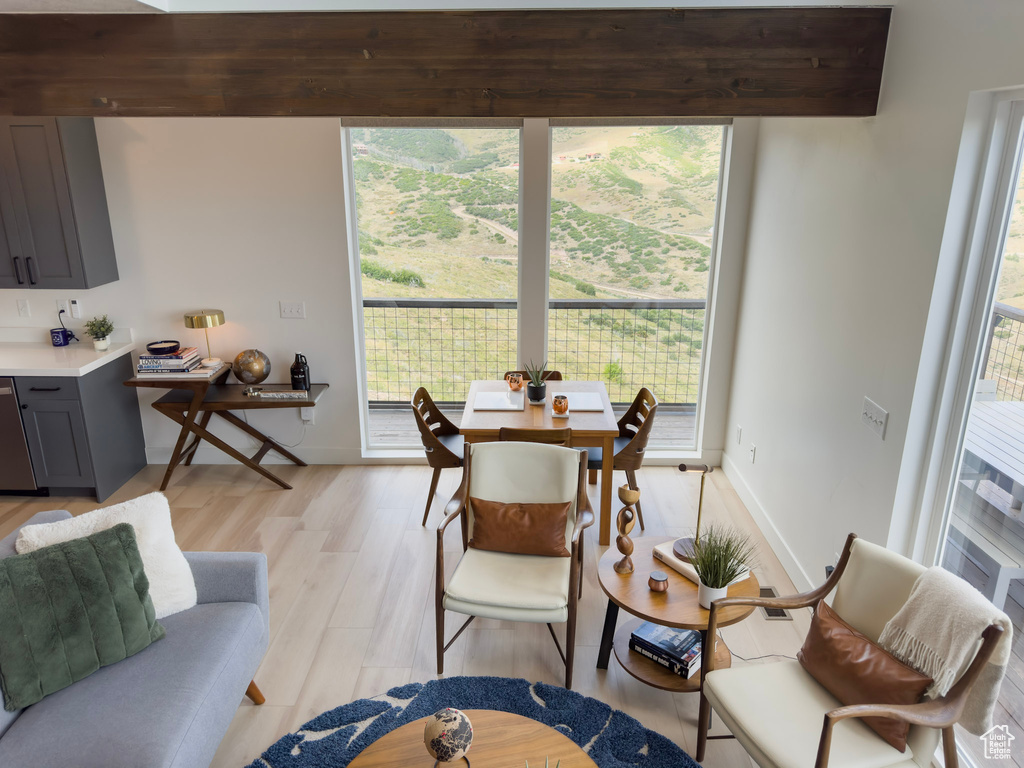 Living area featuring baseboards, light wood finished floors, and expansive windows