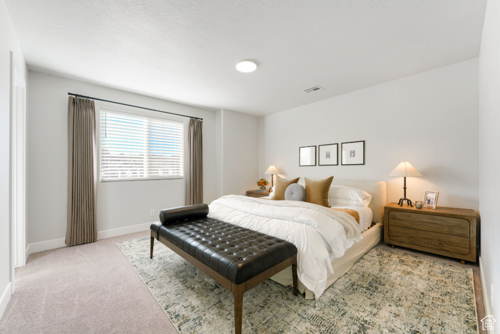 Carpeted bedroom featuring visible vents and baseboards
