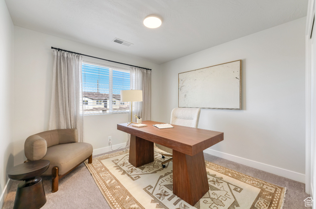 Home office featuring visible vents, light colored carpet, and baseboards