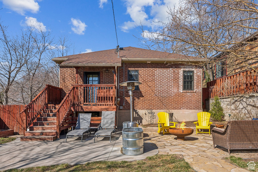 Rear view of property with a patio, fence, an outdoor fire pit, stairs, and brick siding