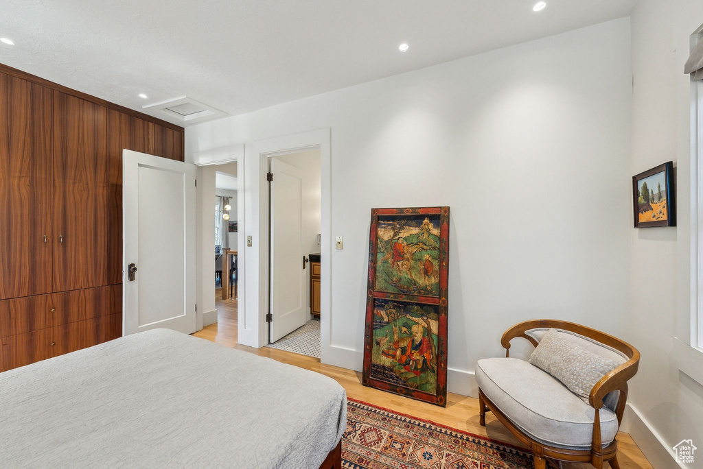Bedroom featuring attic access, light wood-style flooring, recessed lighting, and baseboards