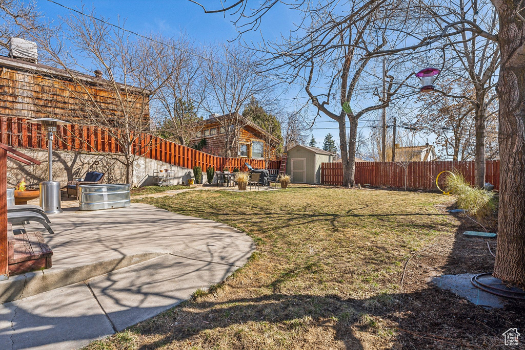 View of yard featuring a patio area, a shed, a fenced backyard, and an outdoor structure