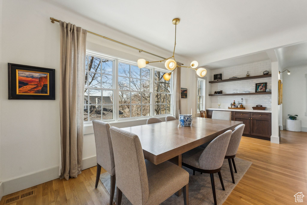 Dining space featuring light wood-style floors, visible vents, and baseboards