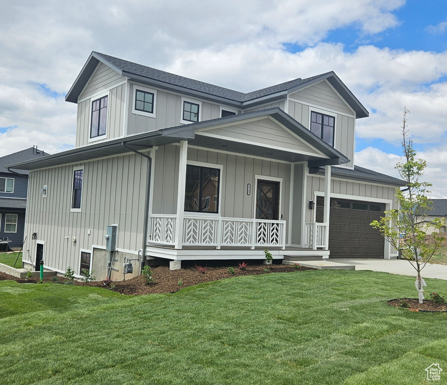Modern farmhouse with a porch, board and batten siding, and a front lawn