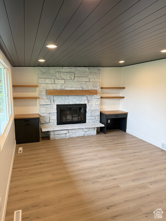 Unfurnished living room with visible vents, baseboards, a stone fireplace, recessed lighting, and light wood-type flooring