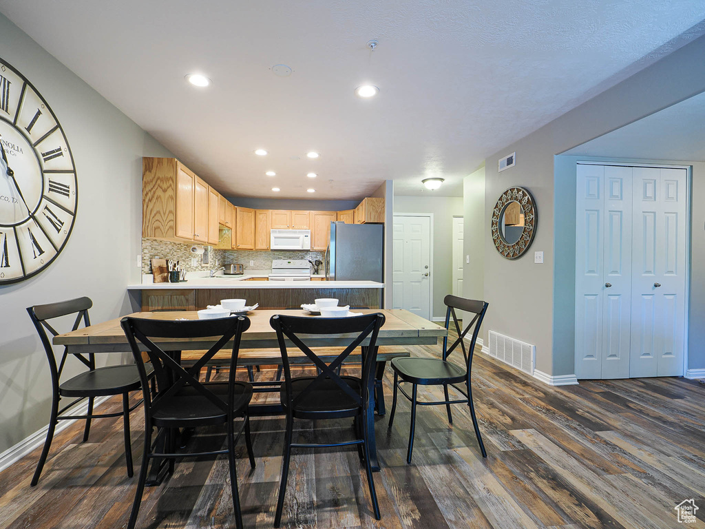 Dining room with baseboards, visible vents, and dark wood-type flooring