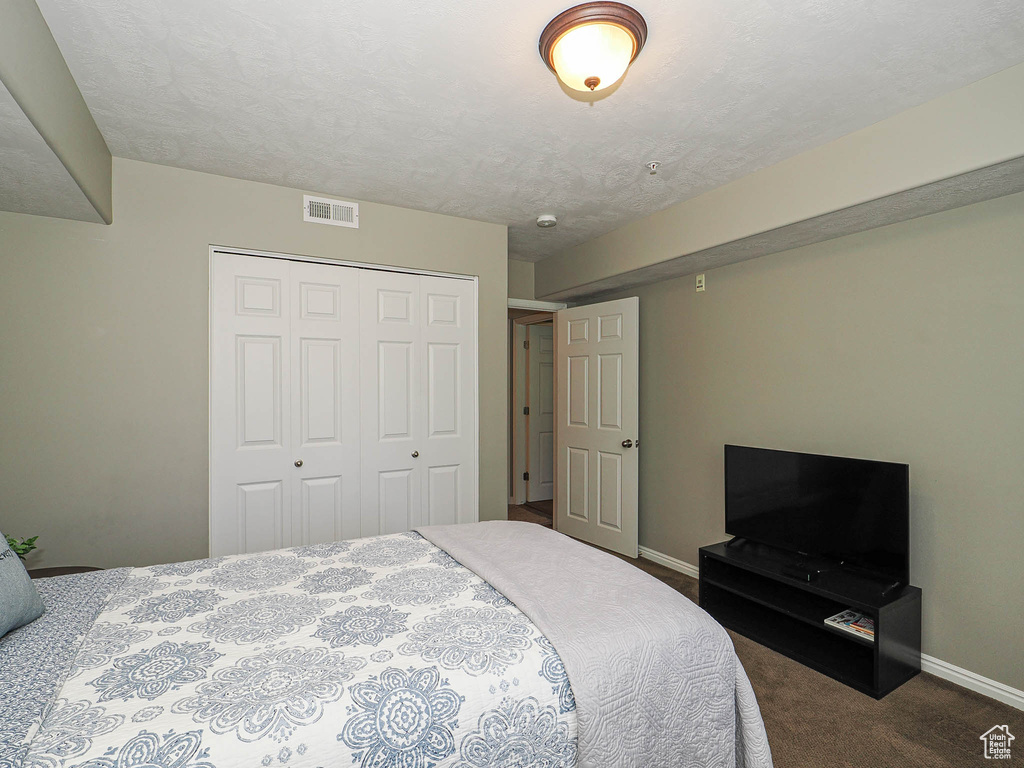 Bedroom featuring visible vents, carpet, baseboards, and a closet