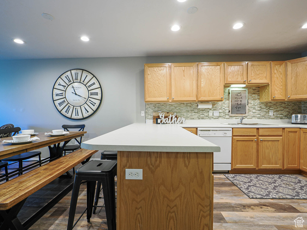 Kitchen with a sink, decorative backsplash, a breakfast bar, and dishwasher