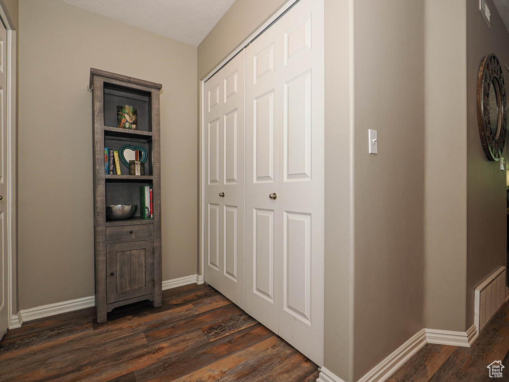 Hallway featuring baseboards and dark wood finished floors