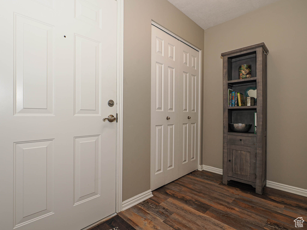 Entrance foyer with baseboards and dark wood-style floors