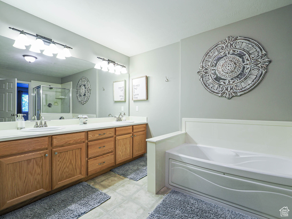 Full bathroom with a sink, double vanity, a stall shower, and a bath