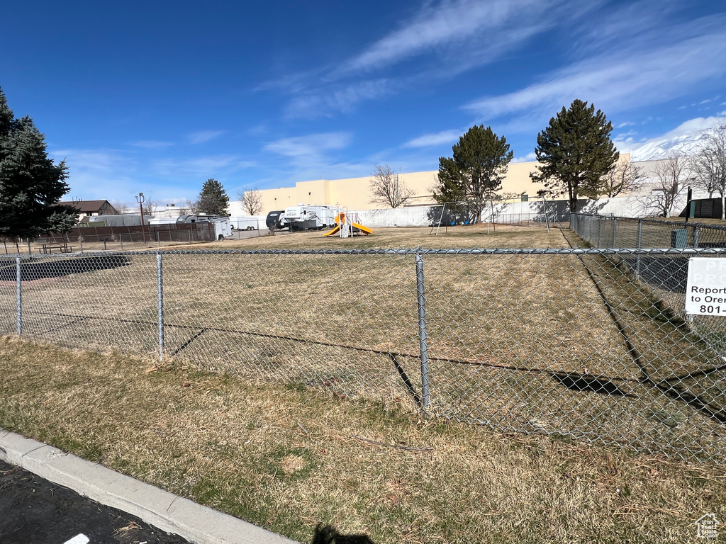View of yard with a playground and fence