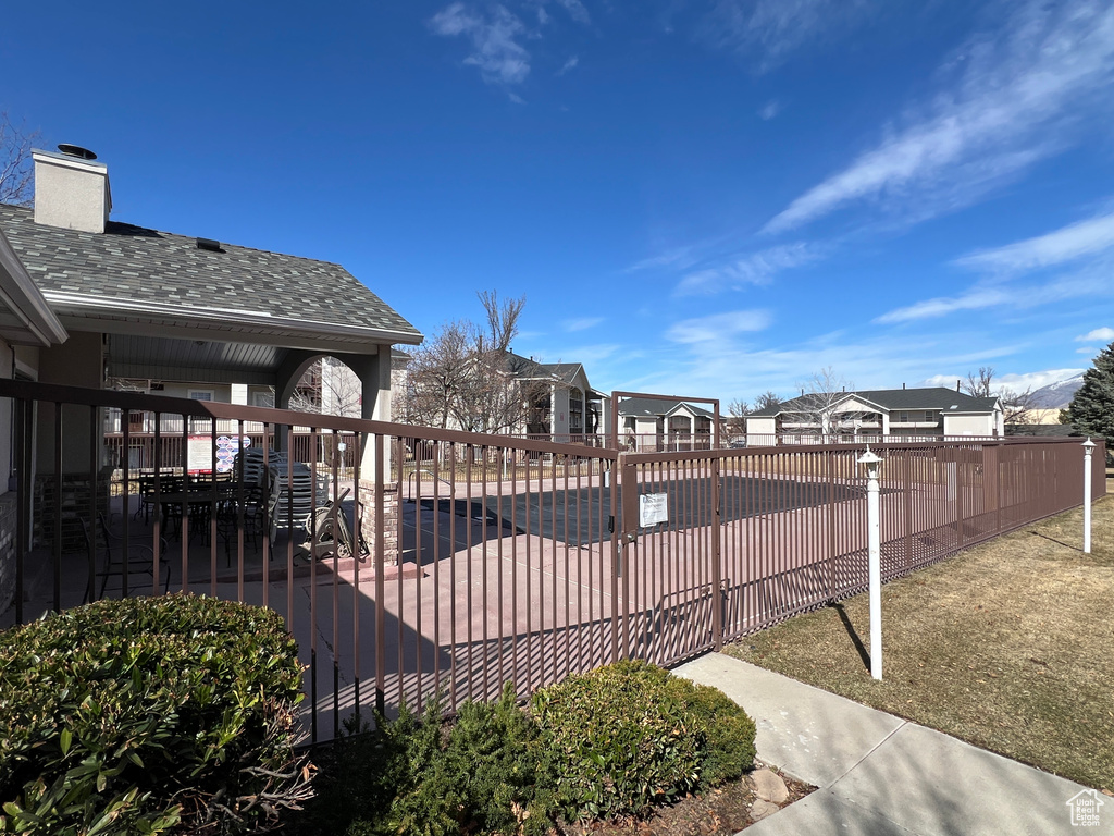 Exterior space with a patio area, a residential view, a swimming pool, and fence