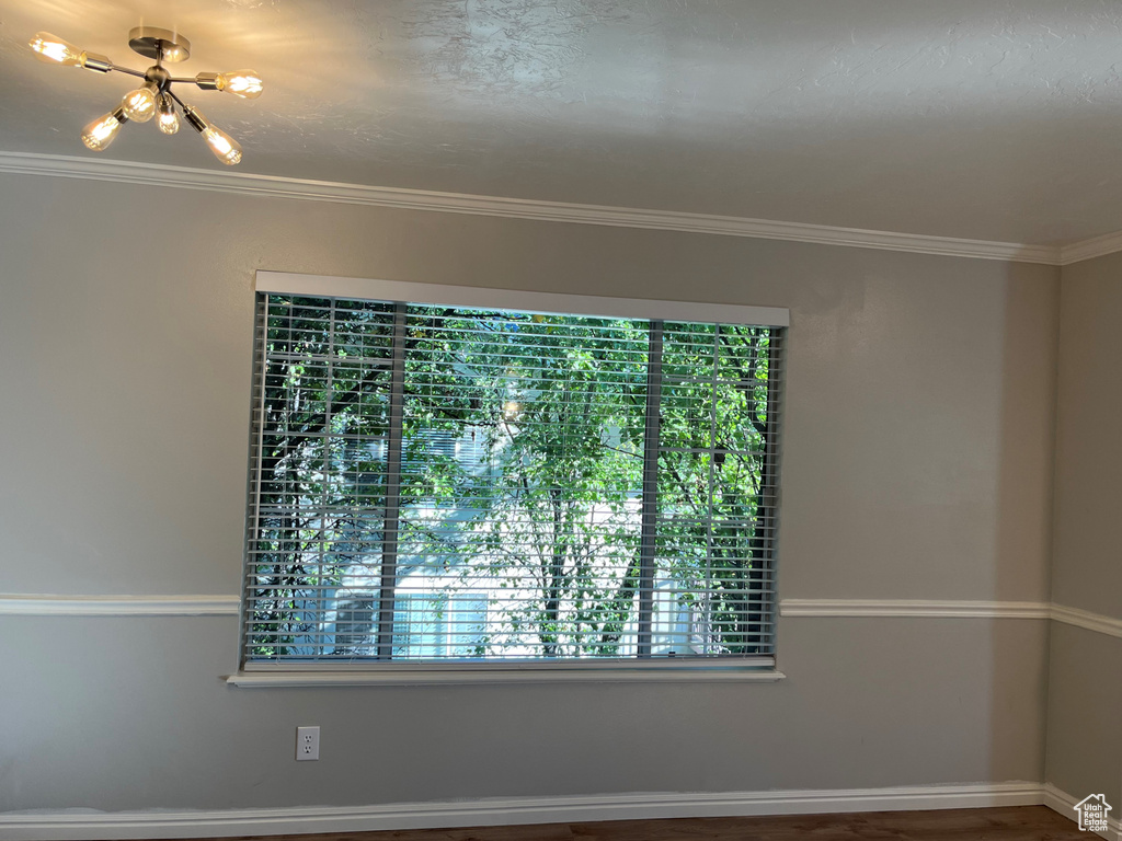 Unfurnished room with a chandelier and crown molding