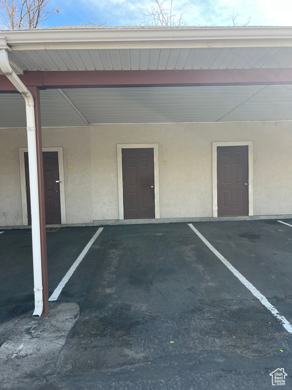Property entrance featuring stucco siding and covered parking