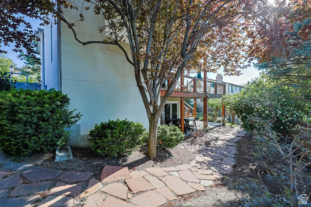 Exterior space with a wooden deck, stucco siding, and a patio