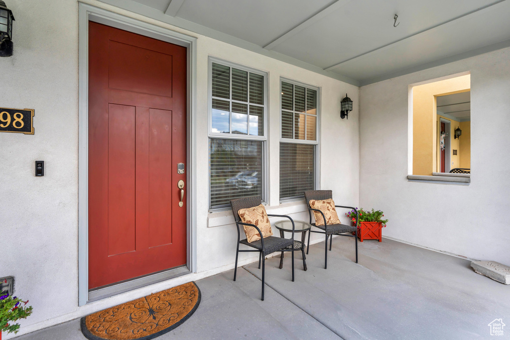 Property entrance featuring stucco siding and covered porch