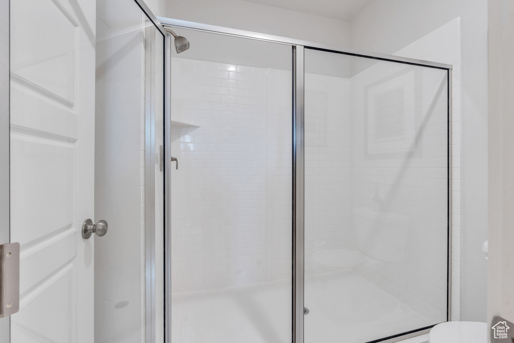 Full bathroom featuring a shower stall and toilet
