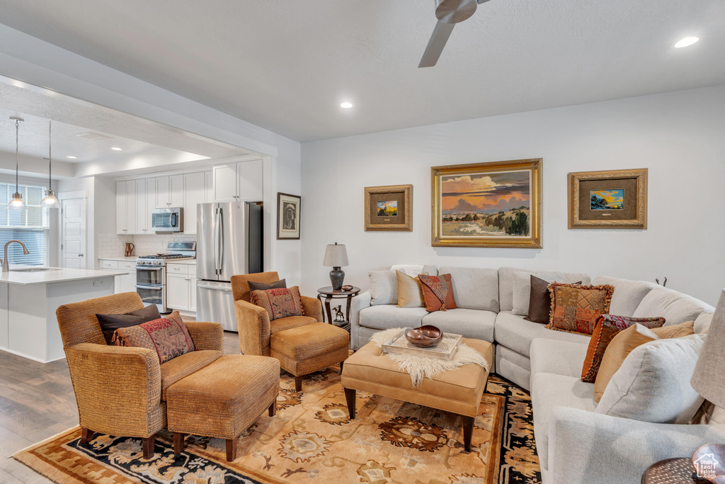 Living room with light wood finished floors, recessed lighting, and ceiling fan