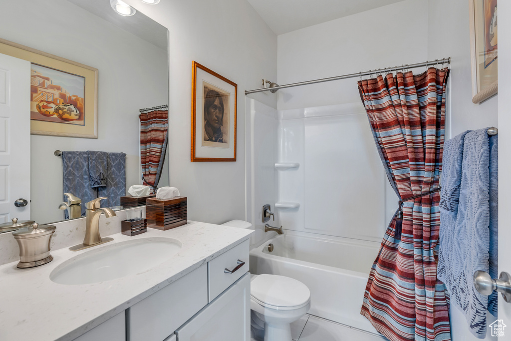 Bathroom with shower / bathtub combination with curtain, toilet, vanity, and tile patterned flooring