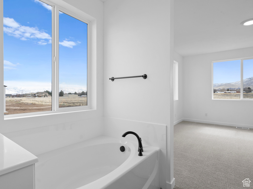 Full bath featuring a bath and baseboards