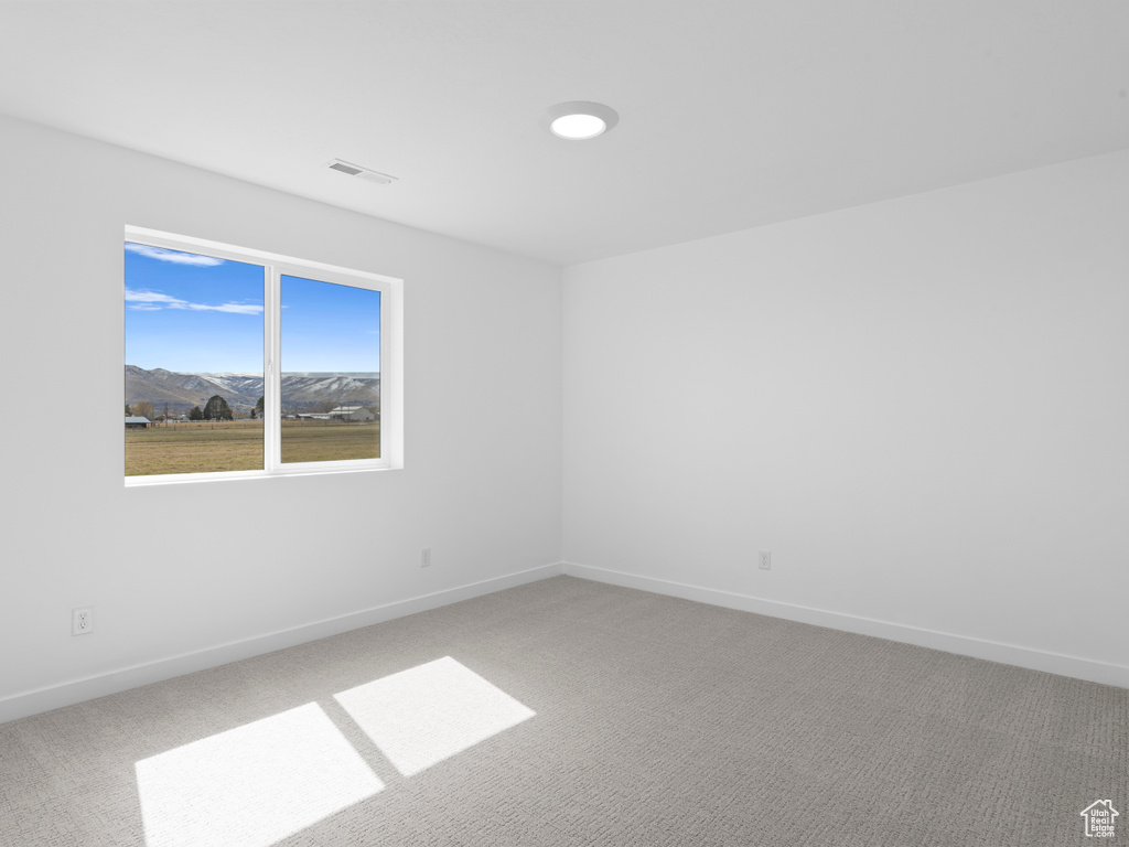 Unfurnished room with baseboards, visible vents, and carpet floors