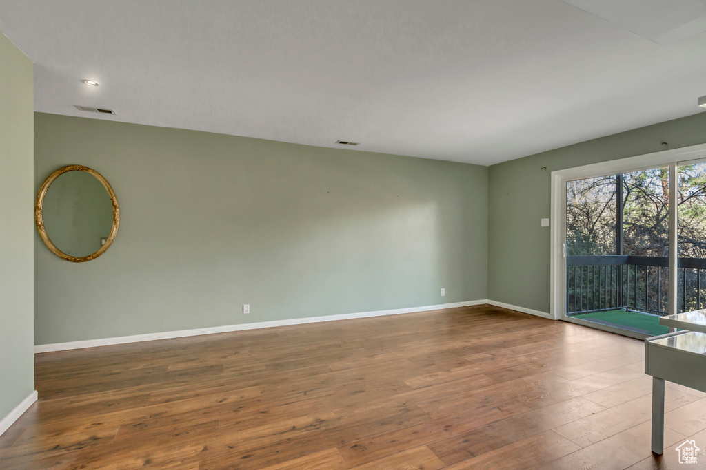 Spare room featuring baseboards, wood-type flooring, and visible vents