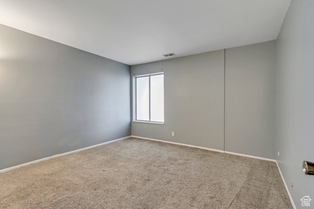 Unfurnished room with visible vents, baseboards, and carpet