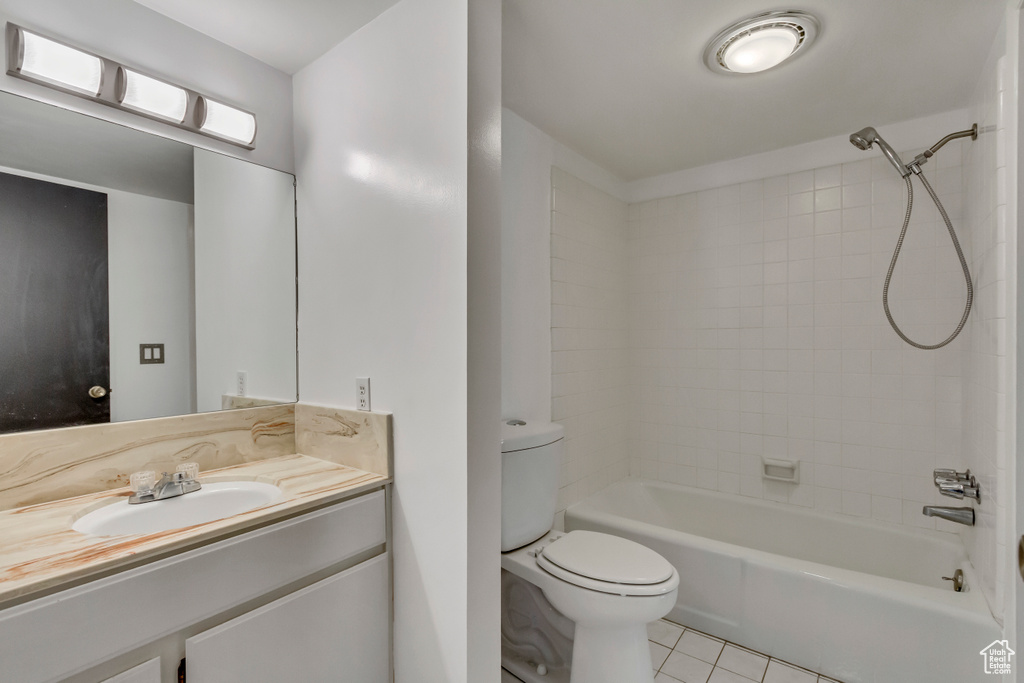 Full bath with tile patterned floors, toilet, vanity, and shower / tub combination