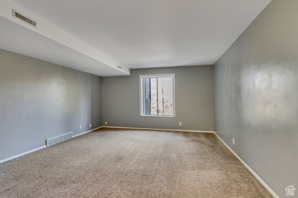 Spare room with visible vents, baseboards, and carpet flooring