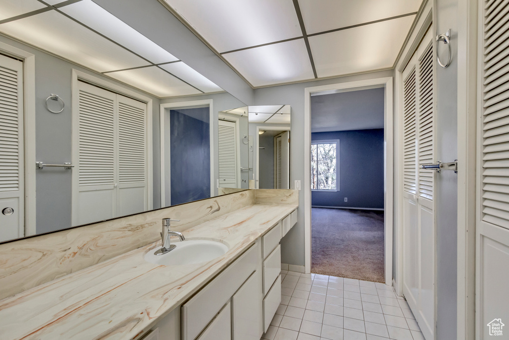 Bathroom featuring a closet, vanity, and tile patterned flooring