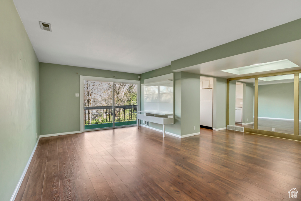 Spare room with visible vents, baseboards, and hardwood / wood-style flooring