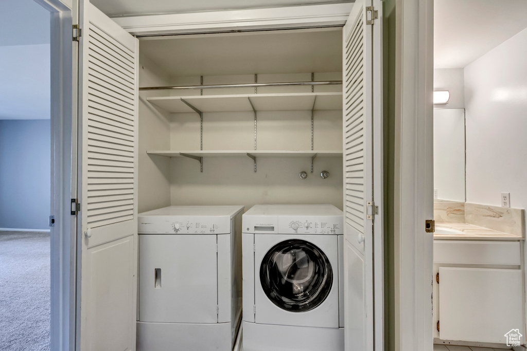 Laundry room with laundry area, washing machine and dryer, and carpet floors