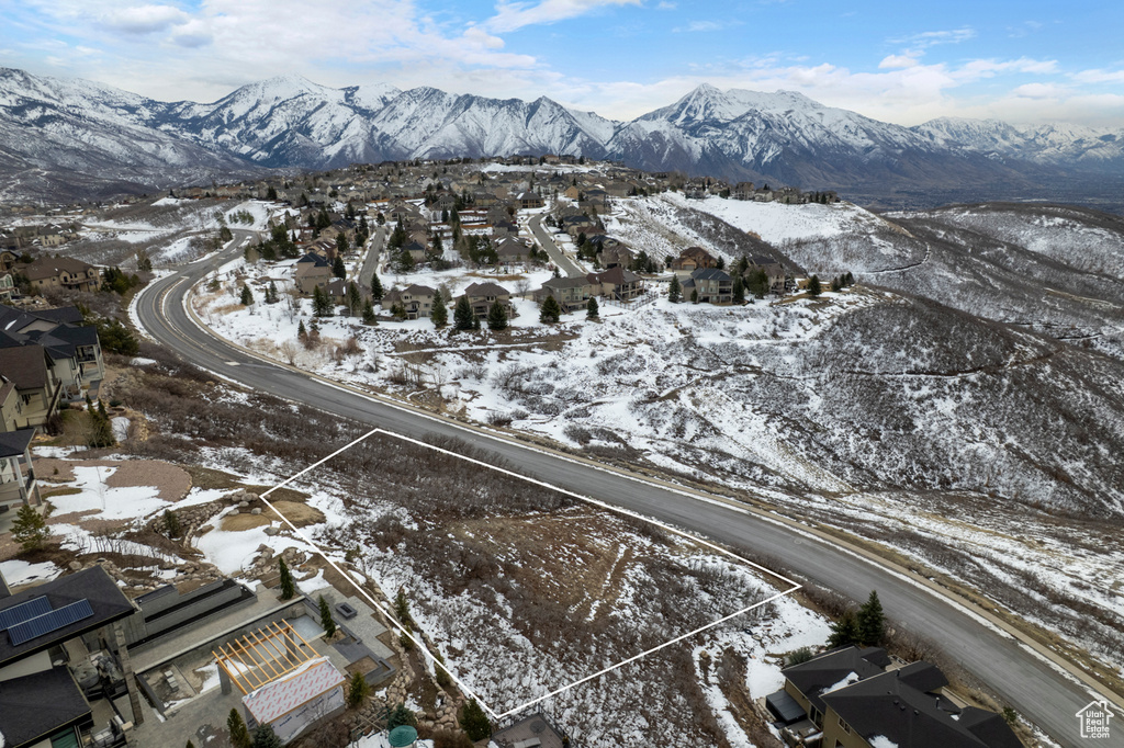 Snowy aerial view featuring a mountain view and a residential view