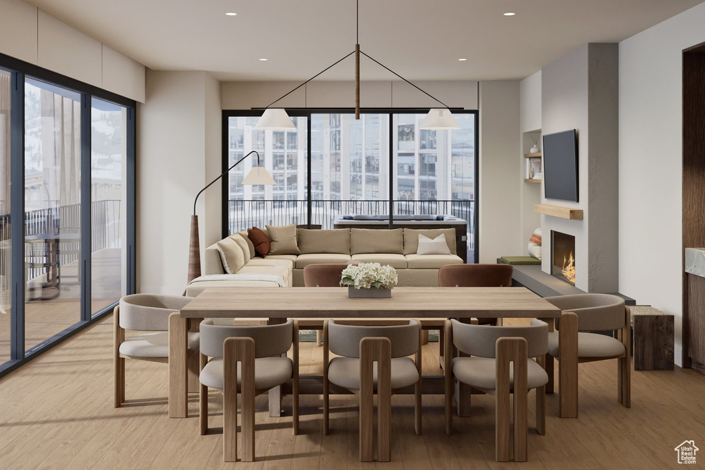 Dining space featuring recessed lighting, light wood-style flooring, and a lit fireplace