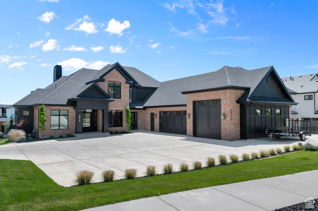 View of front of house featuring brick siding, concrete driveway, roof with shingles, a chimney, and a garage