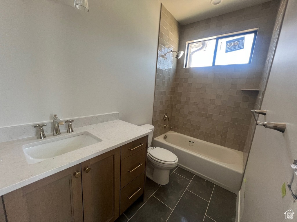 Full bathroom featuring vanity, tile patterned floors, and washtub / shower combination