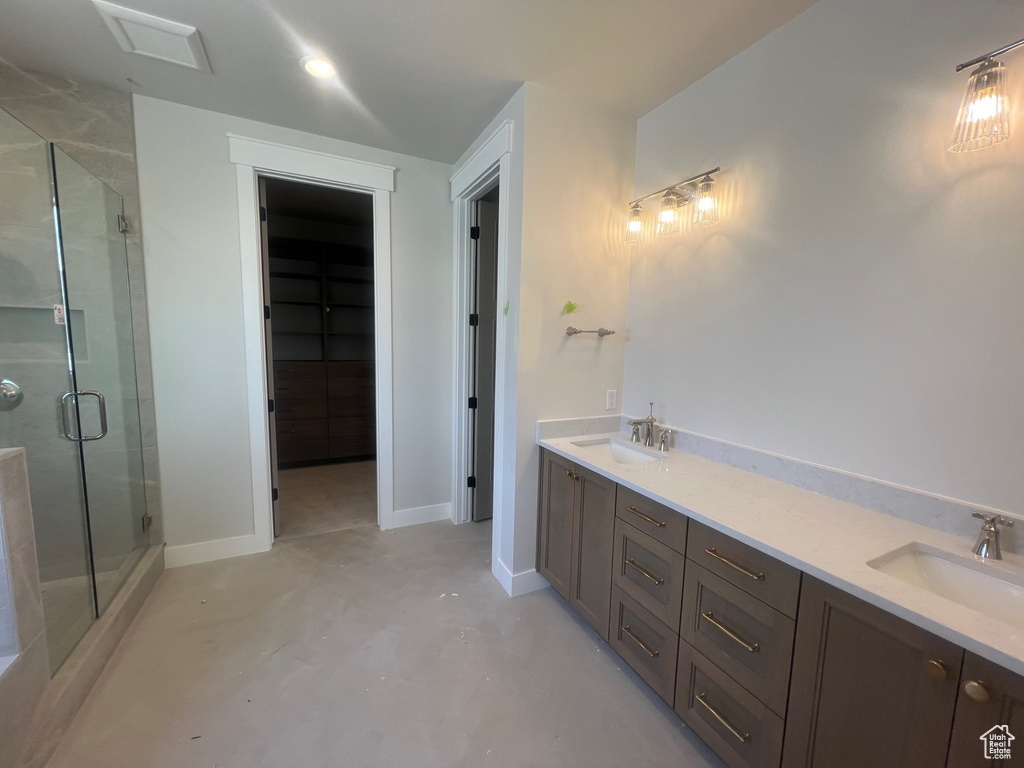 Full bath featuring a stall shower, concrete flooring, and double vanity