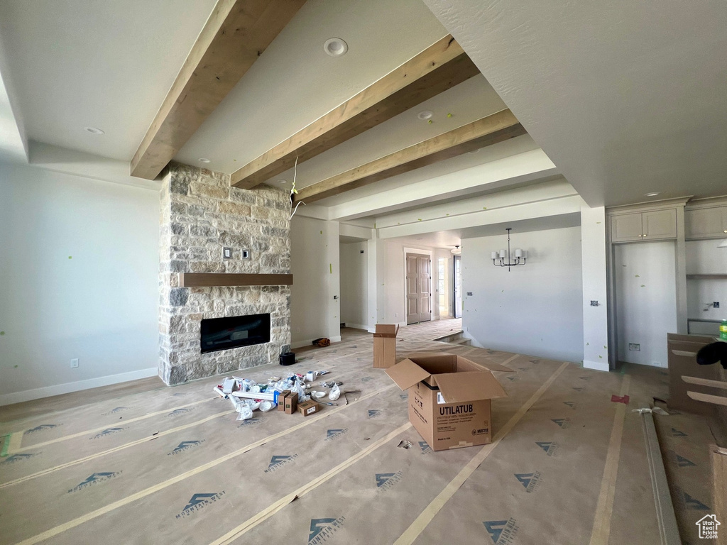 Unfurnished living room featuring a fireplace and beamed ceiling