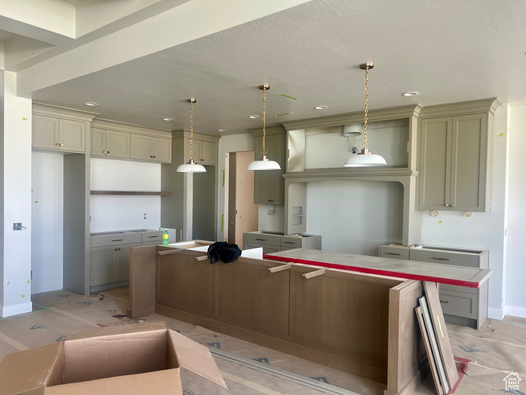 Kitchen featuring a kitchen island, pendant lighting, baseboards, and recessed lighting