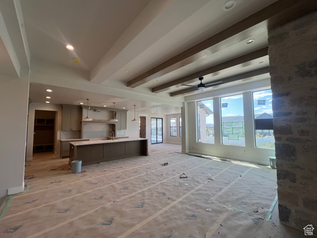 Unfurnished living room featuring beam ceiling, ceiling fan, and recessed lighting
