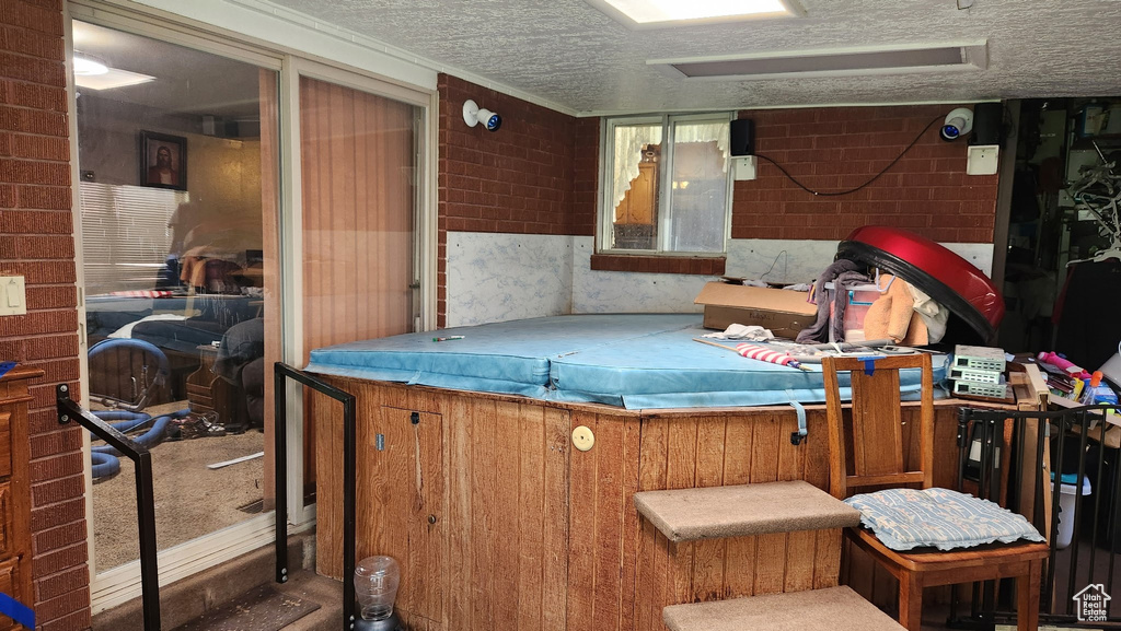 Exterior space with attic access and a textured ceiling