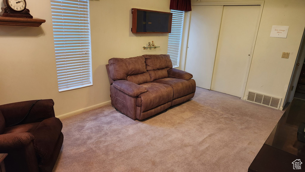 Carpeted living room featuring baseboards and visible vents