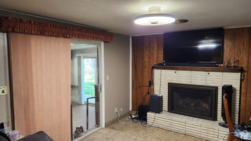 Living room with a textured ceiling, a brick fireplace, and baseboards